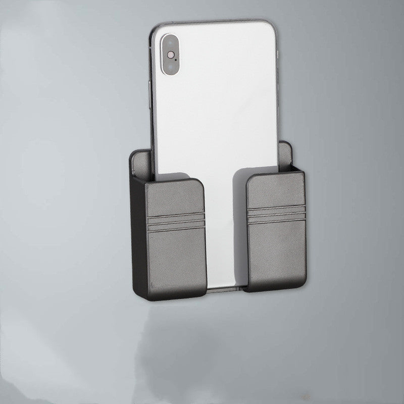 Wall-mounted phone and remote holder beside a bed